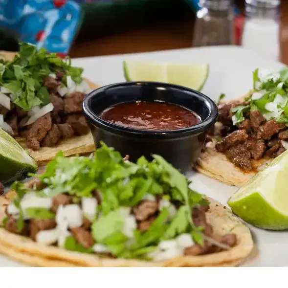 Steak street tacos with cilantro, onion, lime and a cup of salsa